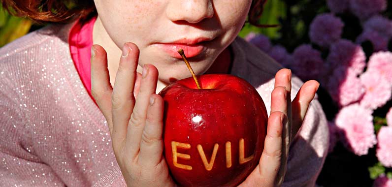  little girl holding an apple laser etched with the word evil